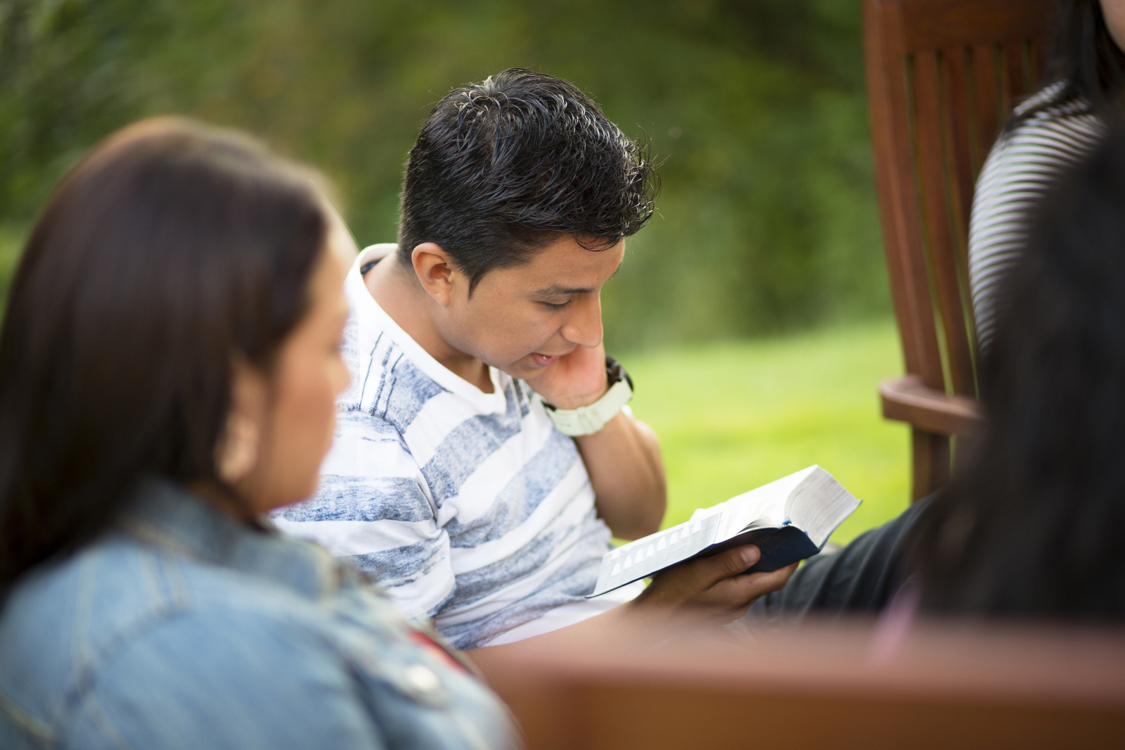 A man reading his scriptures outside